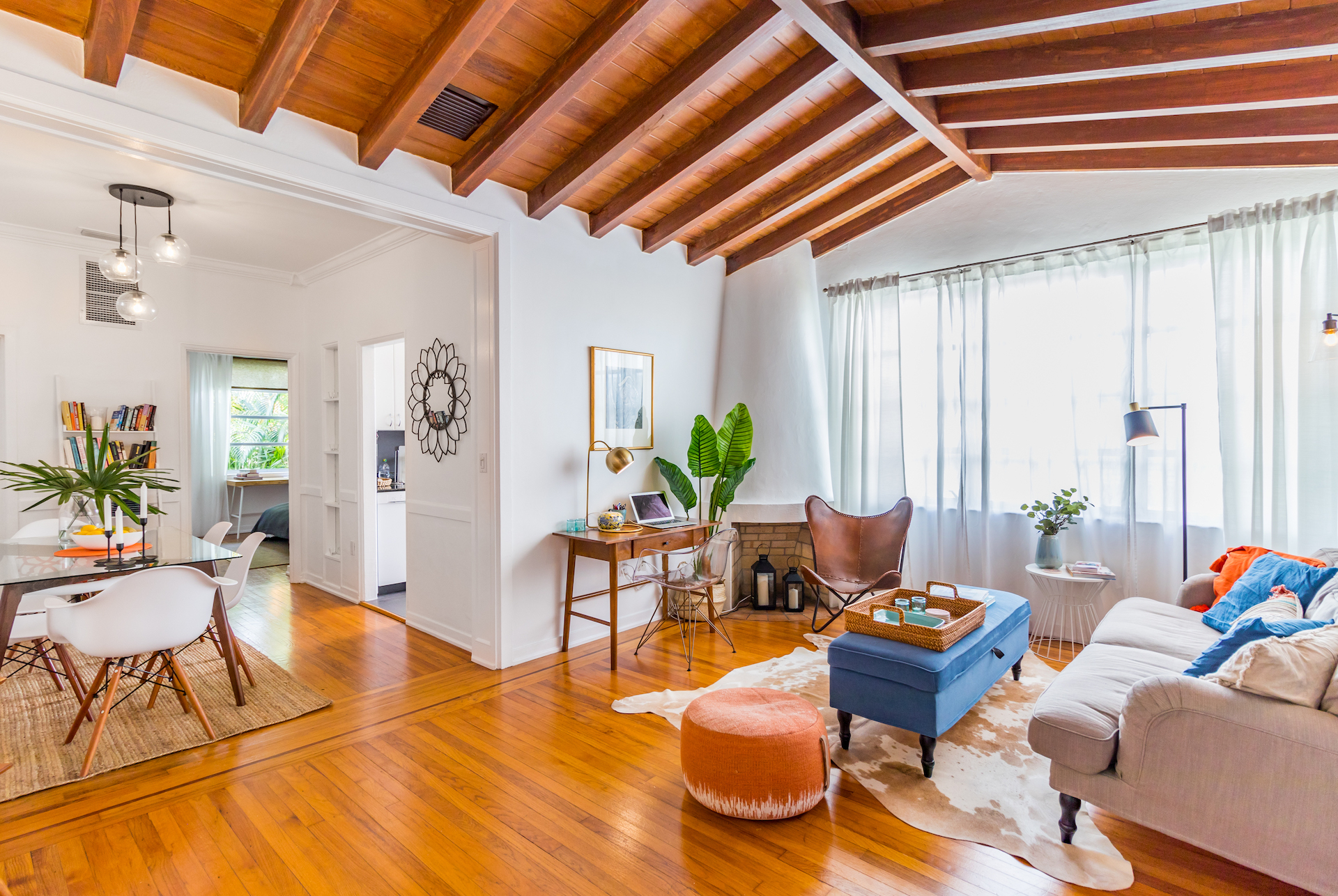 Bright open-concept living space with wood beam ceiling